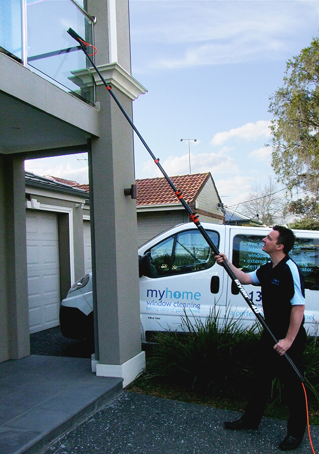 A MyHome window cleaner cleaning a house's glass balcony with the UltraPure window cleaning system